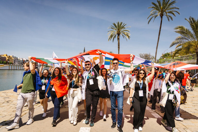 group of volunteers from all around the europe holding a flag during a fag parade