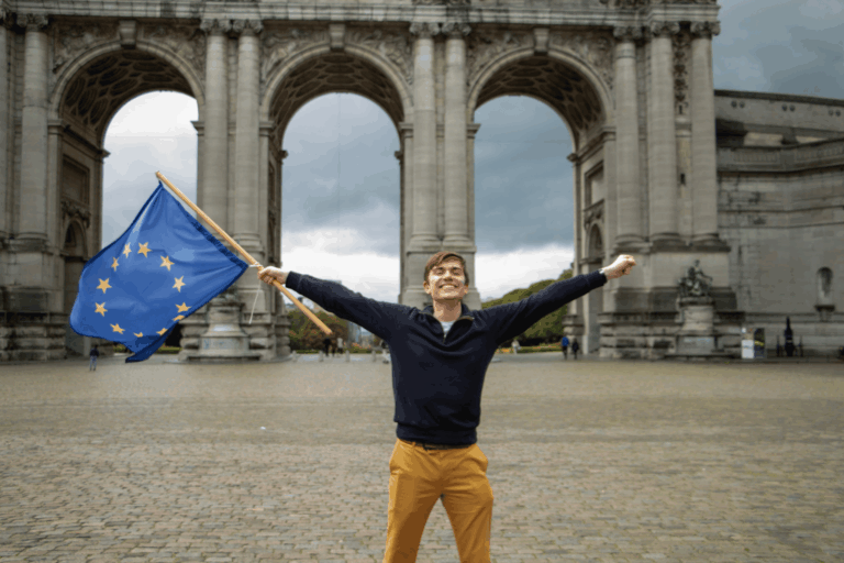 a smiling international student holding a European Flag in a square in Brussel