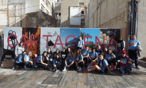 web4 grupo de estudiantes de formación profesional posando delante de un muro que dice cartagena durante su experiencia erasmus.